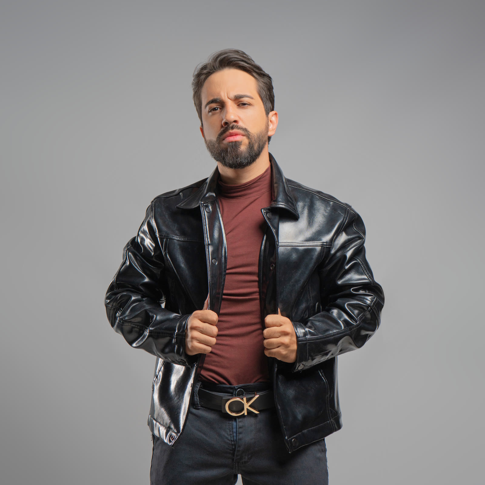 Brener Coelho de jaqueta de couro preta e blusa bordô, olhando para a câmera